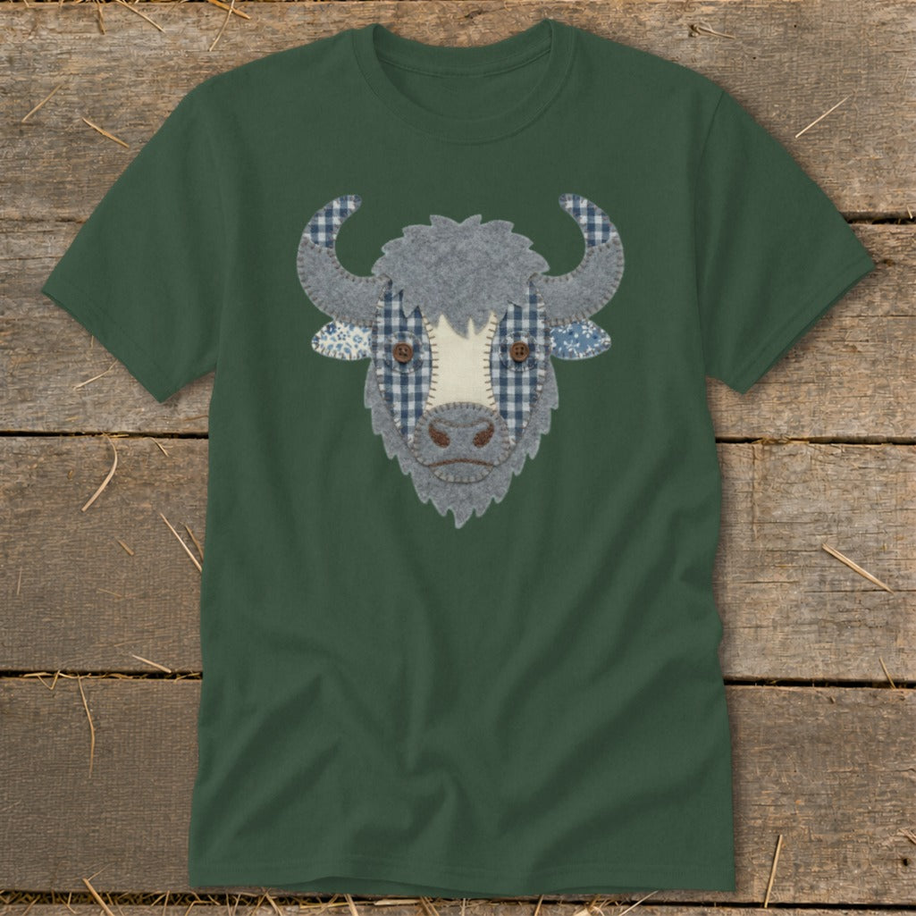 Green t-shirt with a felt appliqué of a cow's face featuring plaid accents.