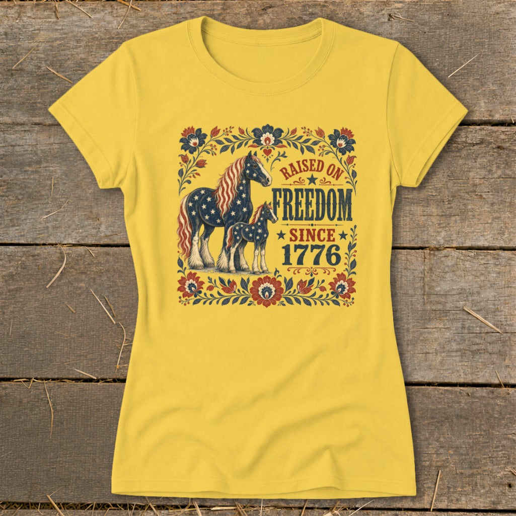 Yellow t-shirt with horses and "Raised on Freedom Since 1776" text.