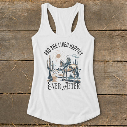 White tank top with graphic of a cowgirl on a horse and text "And She Lived Happily Ever After".