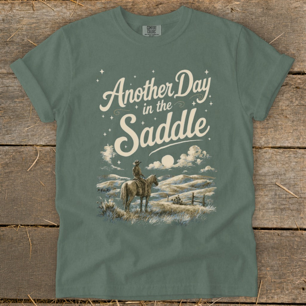 Green t-shirt with "Another Day in the Saddle" text and rider on horseback.