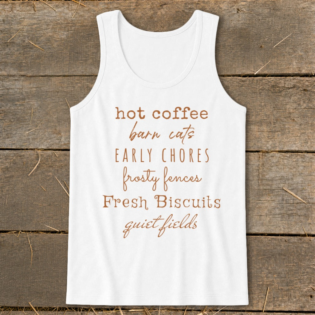 White tank top with brown text listing "hot coffee, barn cats, early chores, frosty fences, fresh biscuits, quiet fields."