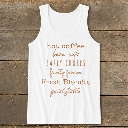 White tank top with brown text listing "hot coffee, barn cats, early chores, frosty fences, fresh biscuits, quiet fields."