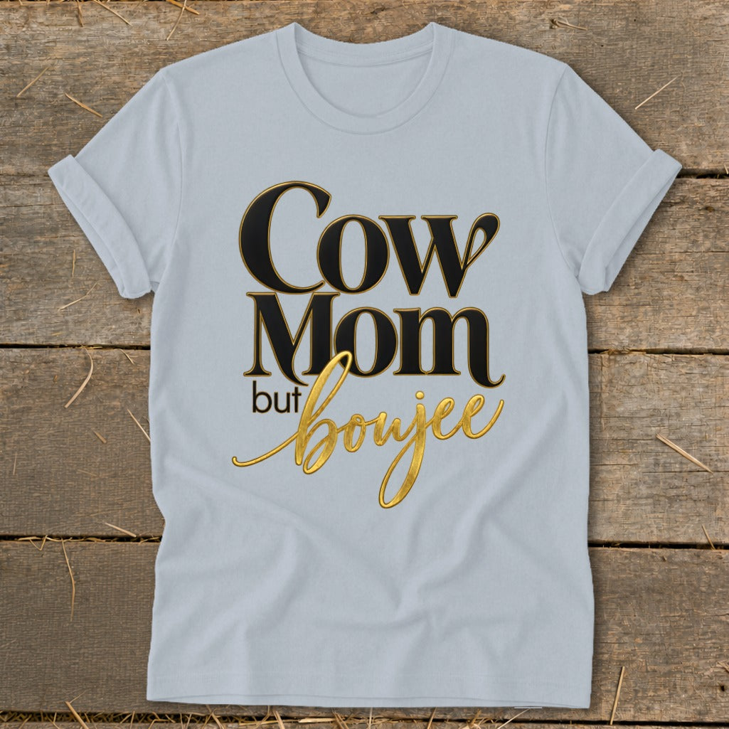 Light blue t-shirt with "Cow Mom but boujee" text in gold and black.