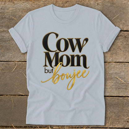 Light blue t-shirt with "Cow Mom but boujee" text in gold and black.