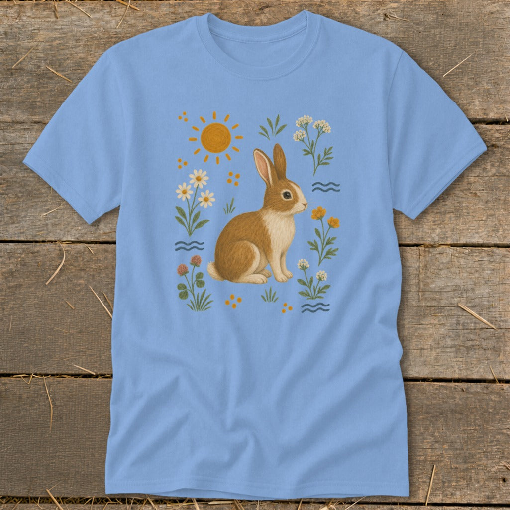 Light blue t-shirt featuring a brown and white rabbit surrounded by flowers and the sun.