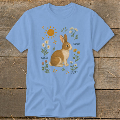 Light blue t-shirt featuring a brown and white rabbit surrounded by flowers and the sun.