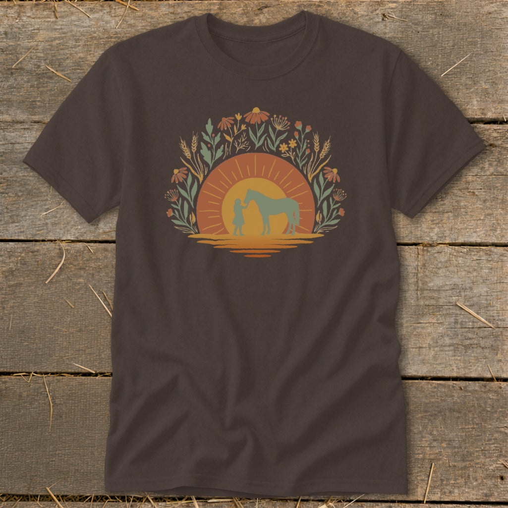 Brown t-shirt with a sunset graphic of a person and horse surrounded by flowers.