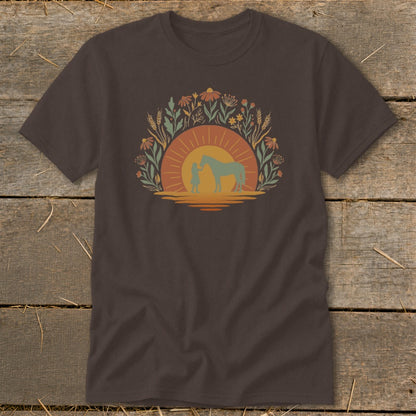 Brown t-shirt with a sunset graphic of a person and horse surrounded by flowers.