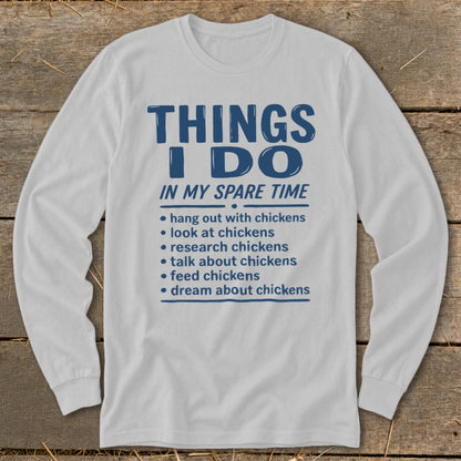White long-sleeve shirt with blue text listing "Things I Do In My Spare Time" and chicken-related activities.