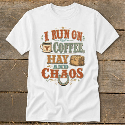 White t-shirt with text "I RUN ON COFFEE, HAY AND CHAOS" featuring a coffee mug, hay bale, and horseshoe.
