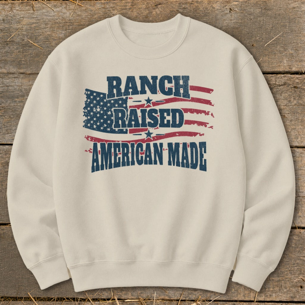 Cream sweatshirt with American flag graphic and text "RANCH RAISED AMERICAN MADE."