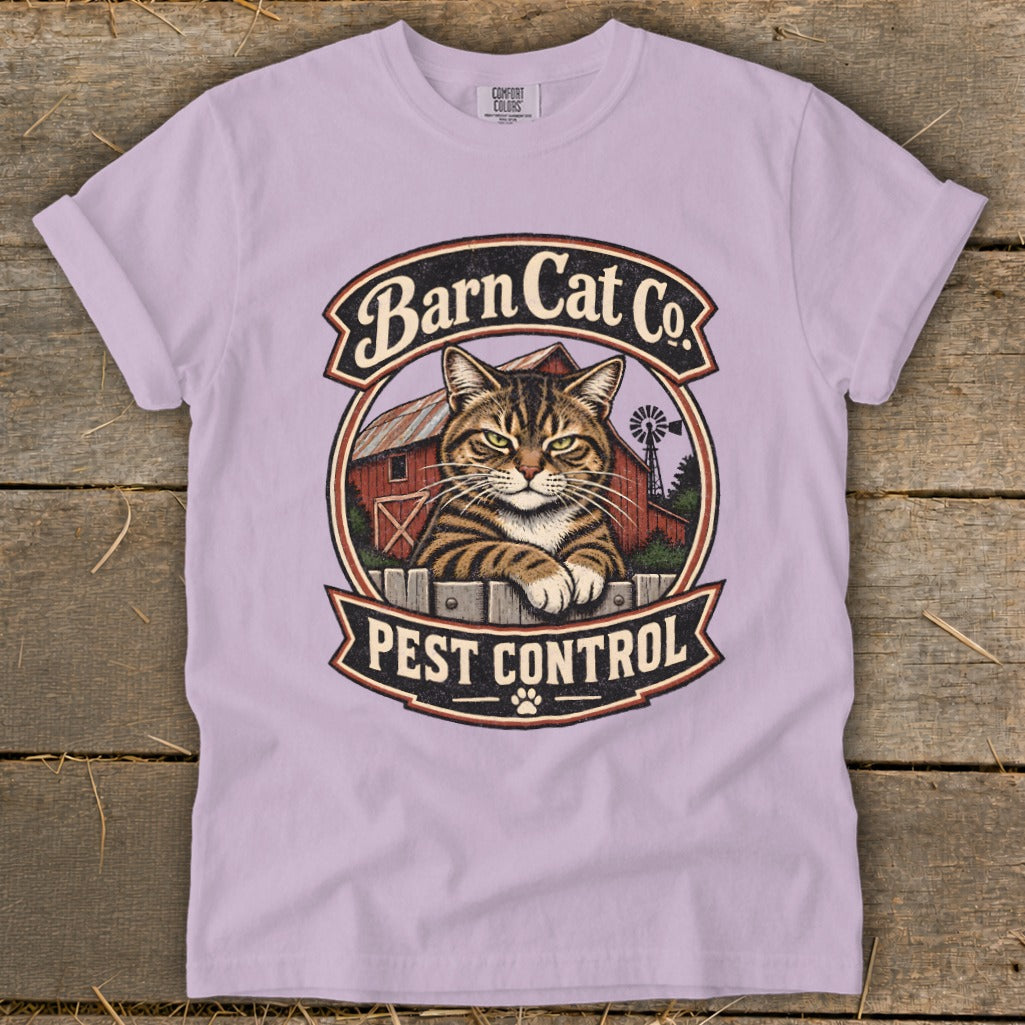 Light purple t-shirt featuring a circular graphic with a tabby cat, a red barn, and the text Barn Cat Co. Pest Control.
