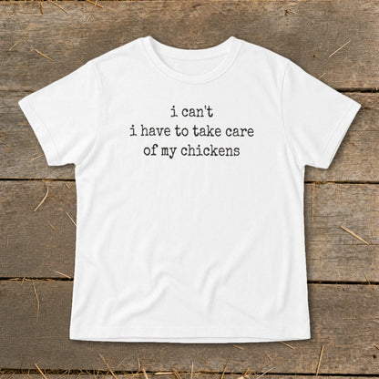 White t-shirt with black text that reads "i can't i have to take care of my chickens".