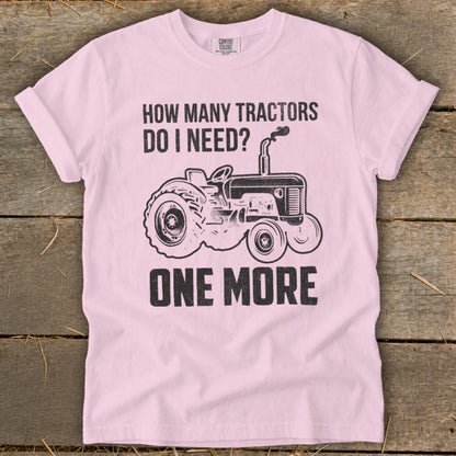 Pink t-shirt with black text and tractor graphic: "How Many Tractors Do I Need? One More"