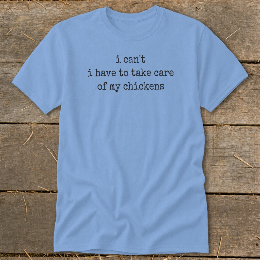 Light blue t-shirt with black text reading "i can't i have to take care of my chickens".