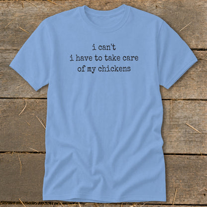 Light blue t-shirt with black text reading "i can't i have to take care of my chickens".