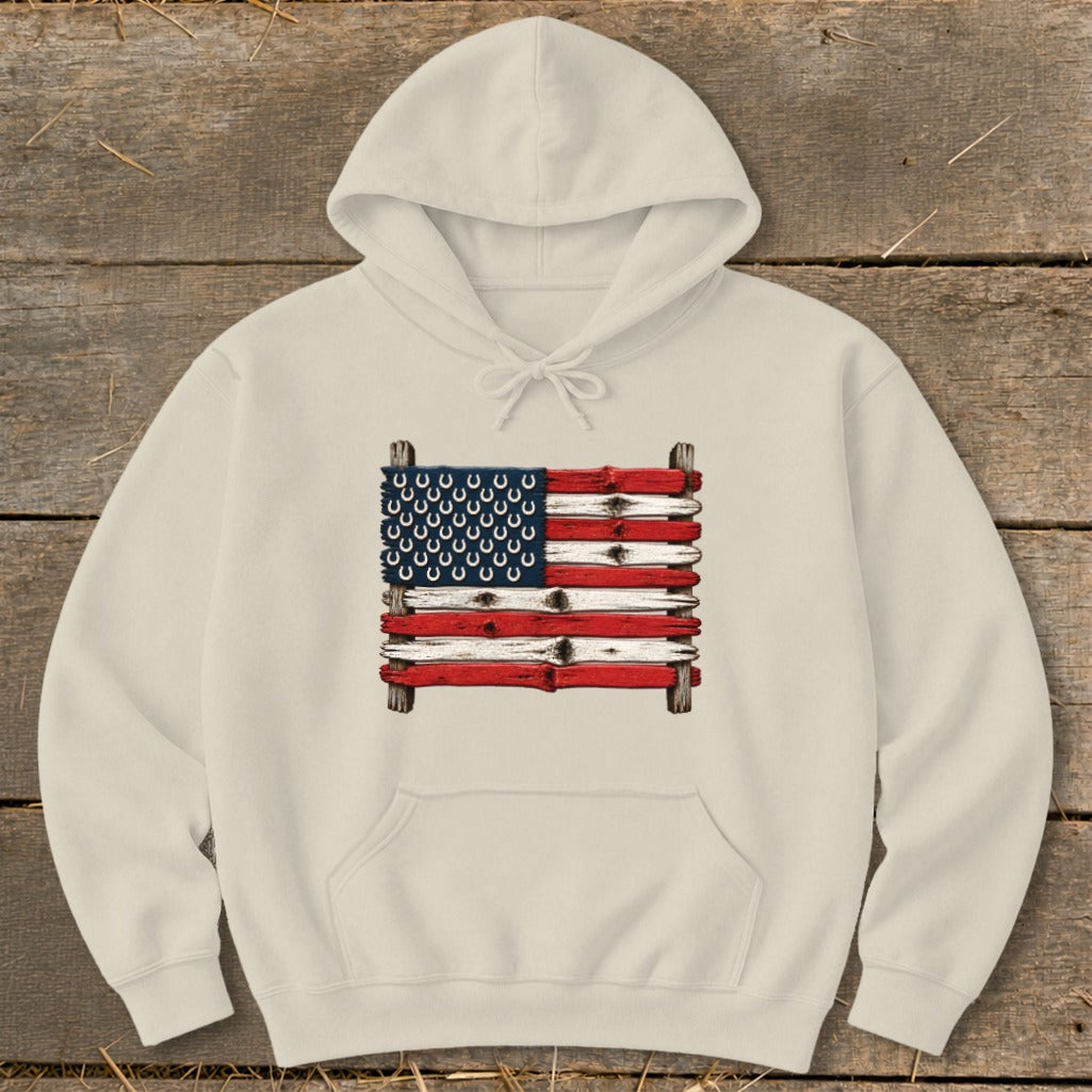 Cream-colored hooded sweatshirt featuring a graphic of an American flag made from weathered wooden planks and horseshoes.
