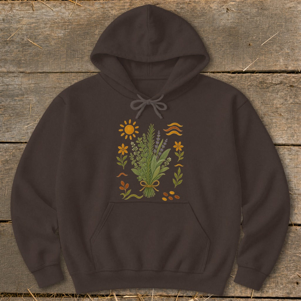 Brown hoodie with a botanical illustration of herbs, flowers, sun, and wavy lines.