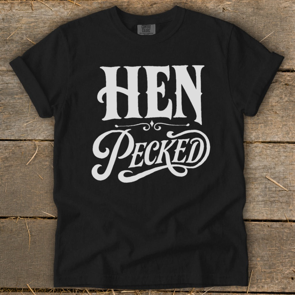 Black t-shirt with white "HEN Pecked" text in vintage lettering.