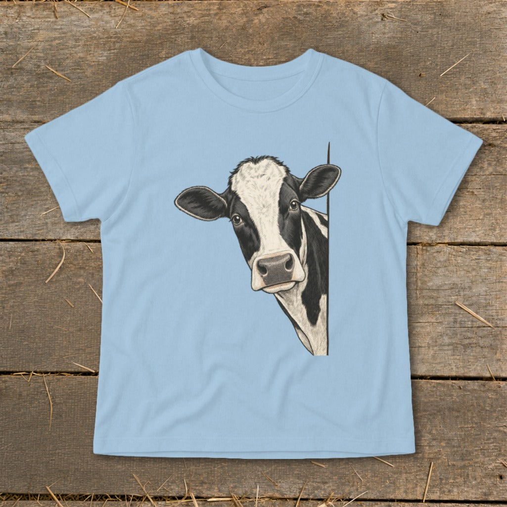 Black and white cow peeking from behind a light blue t-shirt.