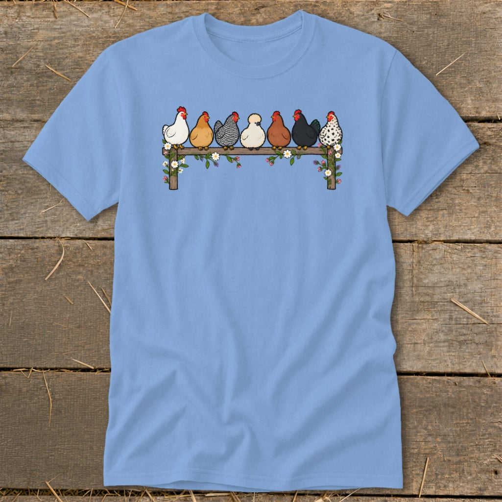 Light blue t-shirt featuring a graphic of seven colorful chickens roosting on a flower-covered wooden fence.