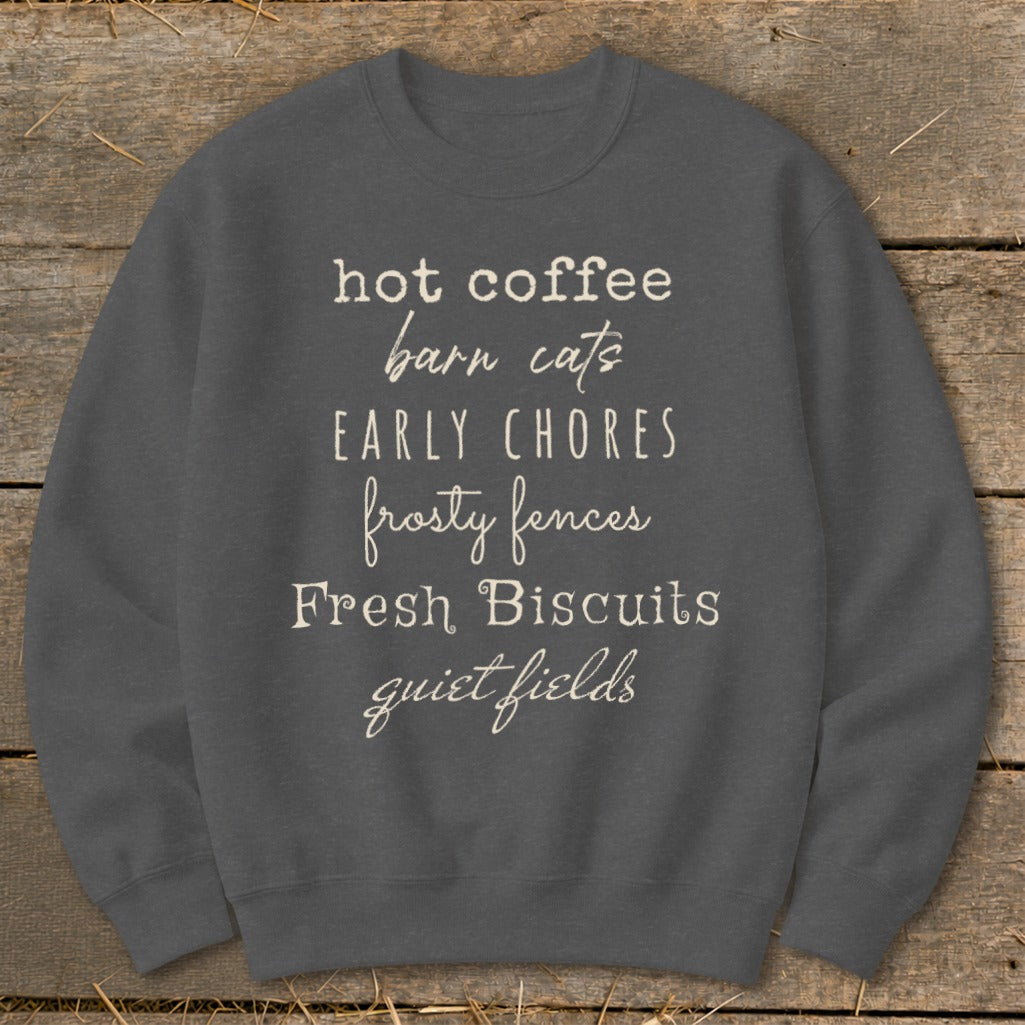 Dark gray sweatshirt with text: hot coffee, barn cats, EARLY CHORES, frosty fences, Fresh Biscuits, quiet fields.