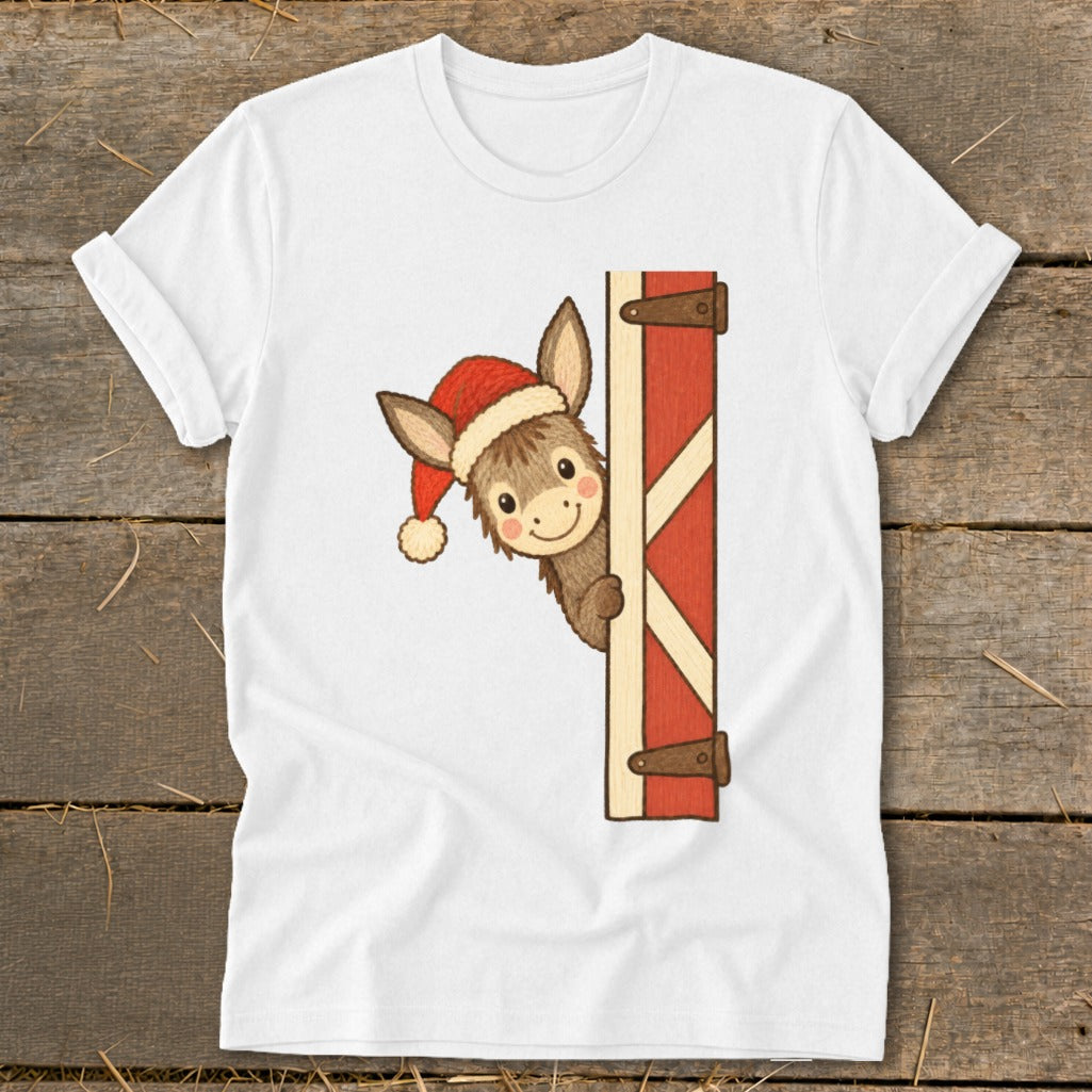 White t-shirt with a cartoon donkey wearing a Santa hat peeking around a barn door.