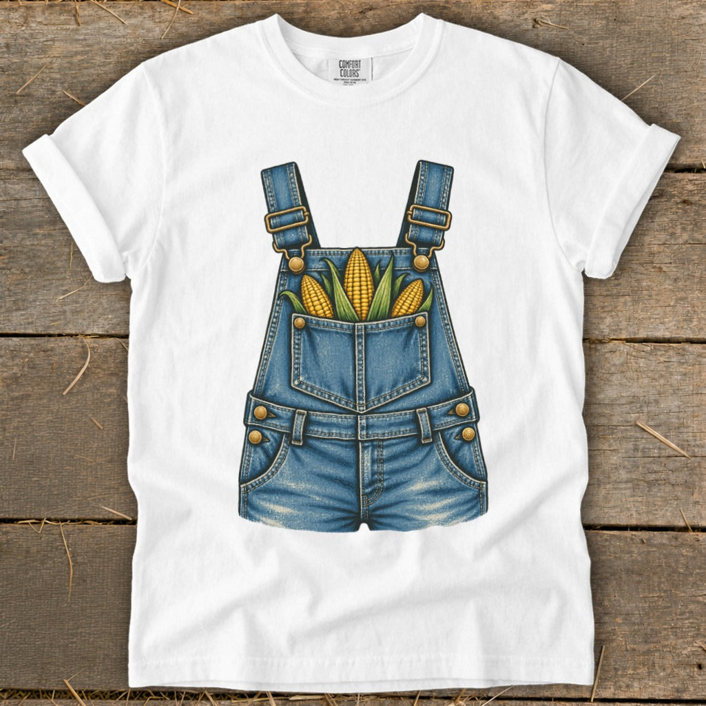 White t-shirt with a graphic of denim overalls filled with corn on the cob.