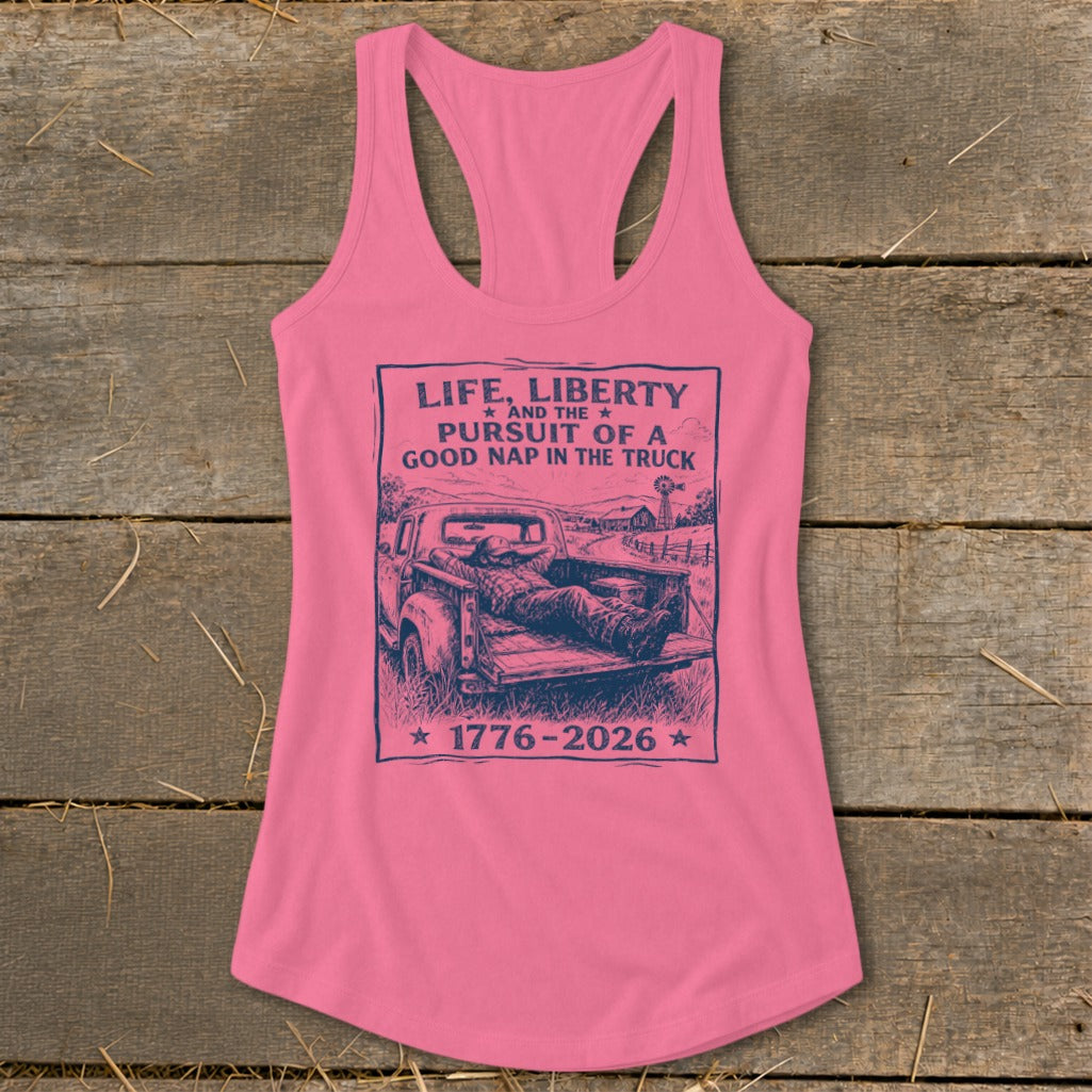 Pink tank top with "Life, Liberty and the Pursuit of a Good Nap in the Truck 1776-2026" graphic.