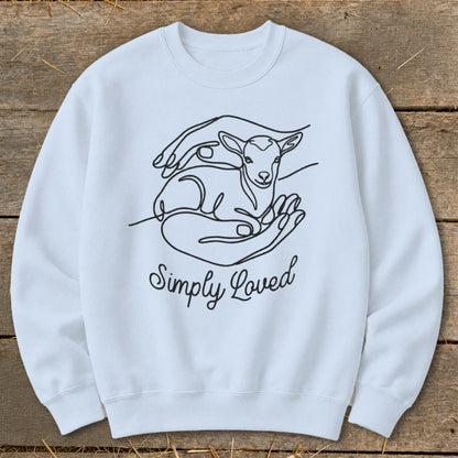 Light blue crewneck sweatshirt with line art of a lamb in hands and "Simply Loved" text.