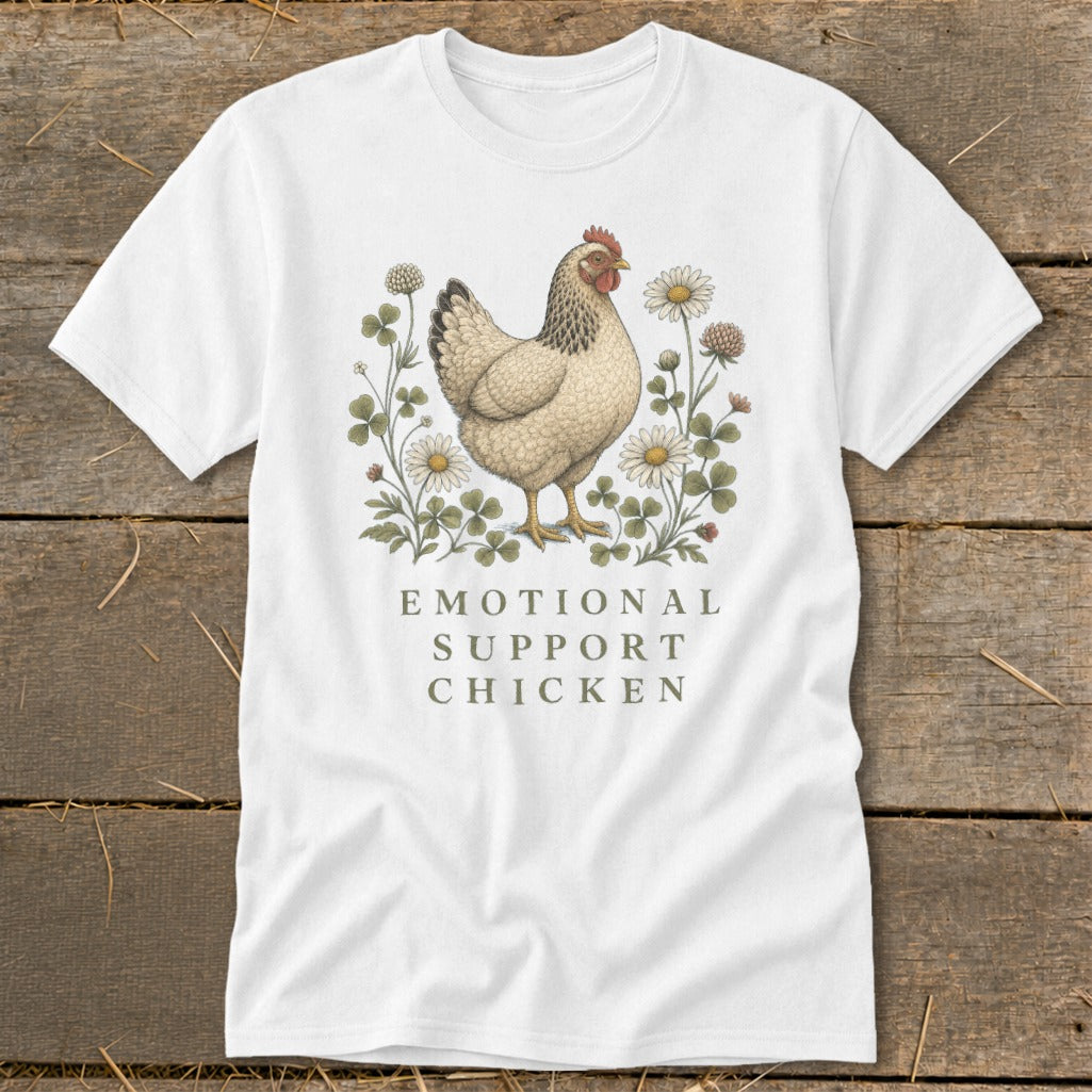 White t-shirt with a beige chicken illustration surrounded by clover and daisies, text reads "EMOTIONAL SUPPORT CHICKEN".