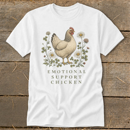 White t-shirt with a beige chicken illustration surrounded by clover and daisies, text reads "EMOTIONAL SUPPORT CHICKEN".