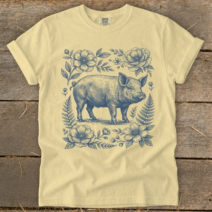 Yellow t-shirt with blue vintage pig and floral sketch graphic.