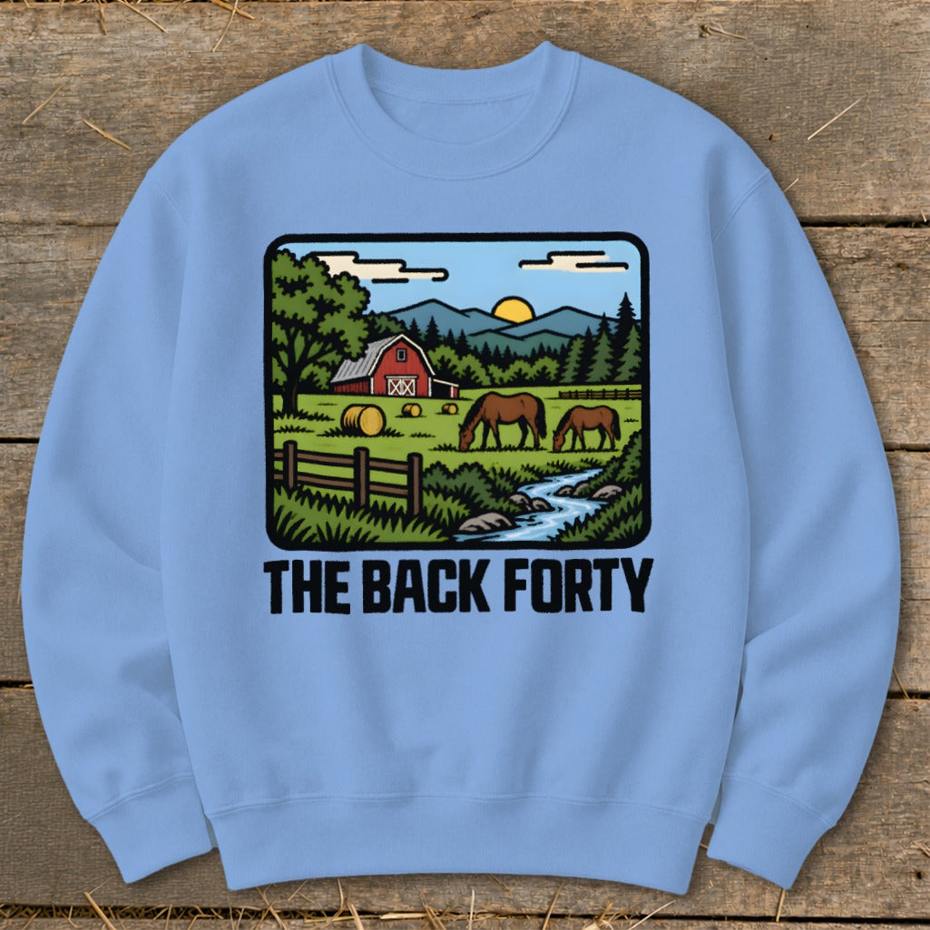 Light blue crewneck sweatshirt featuring a countryside illustration with horses, a red barn, and the text The Back Forty.