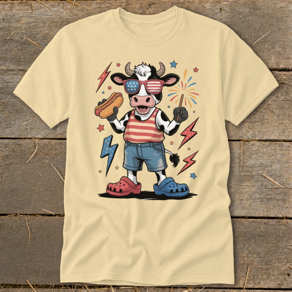 Cow wearing sunglasses, holding hot dog and sparkler, surrounded by lightning bolts and stars.