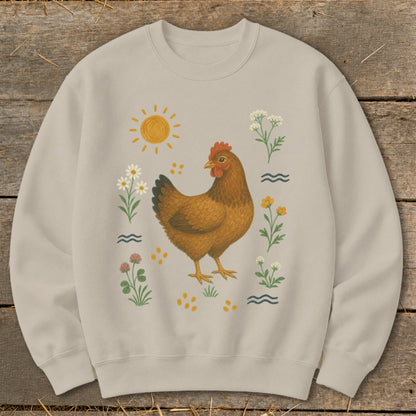 Tan crewneck sweatshirt with a brown chicken surrounded by wildflowers, sun, and wavy lines.