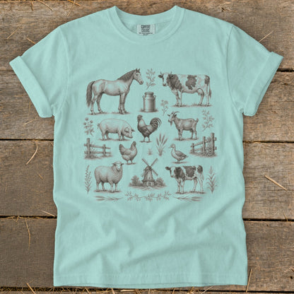 Light blue t-shirt with vintage farm animal illustrations: horse, cow, pig, rooster, goat, sheep, duck, and calf.