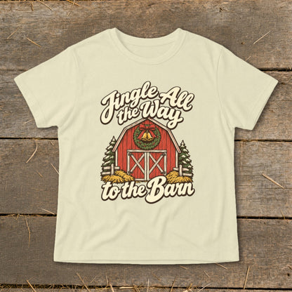 Cream t-shirt with graphic of red barn, Christmas wreath, and text "Jingle All the Way to the Barn".
