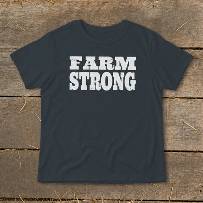 Dark gray short-sleeve t-shirt with white distressed text reading FARM STRONG on a wooden surface.