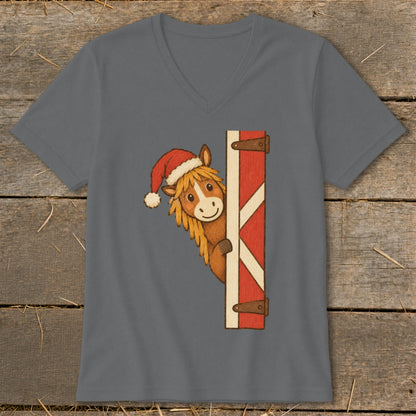 Cartoon horse wearing a Santa hat peeking from behind a red barn door.