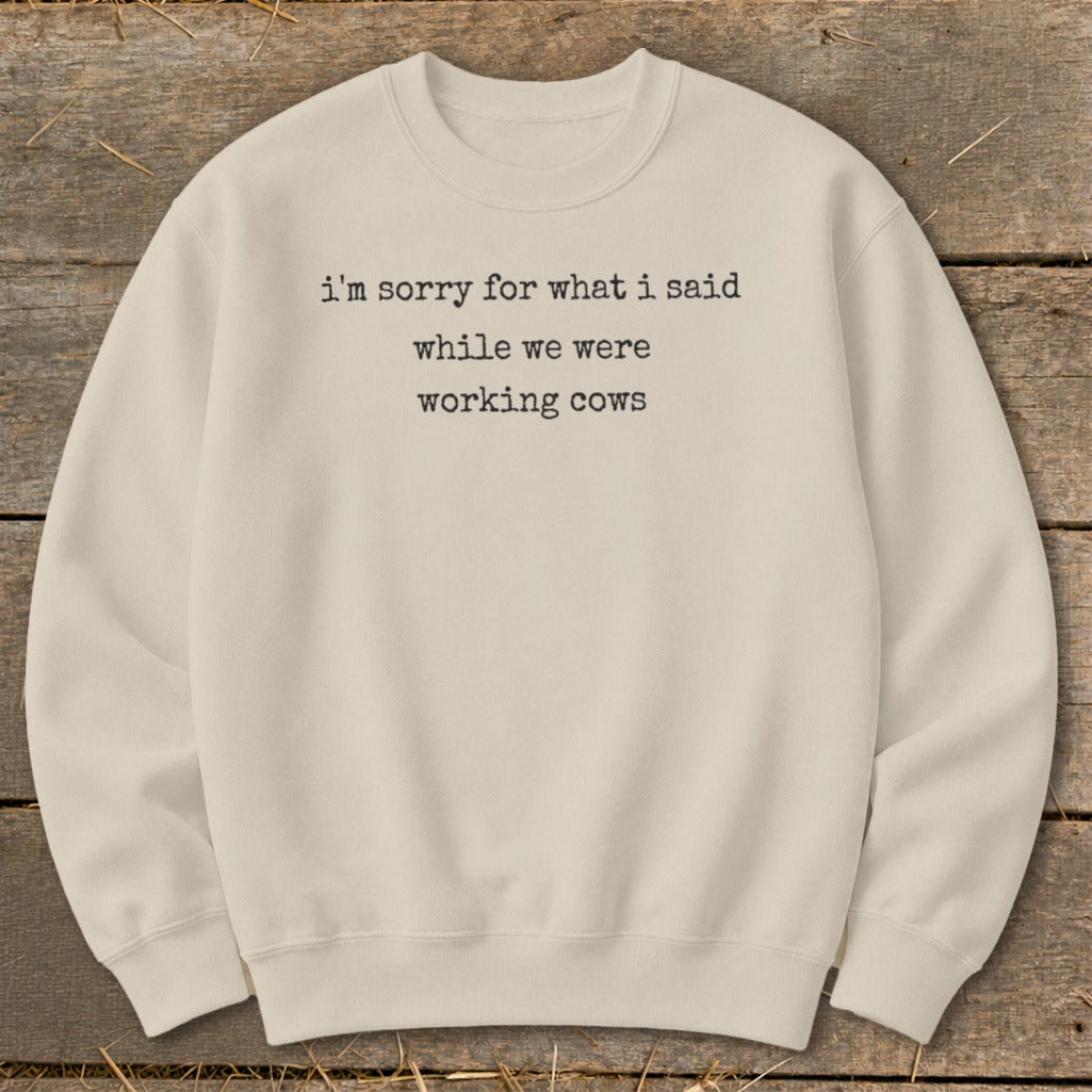 Cream sweatshirt with black text: "i'm sorry for what i said while we were working cows".