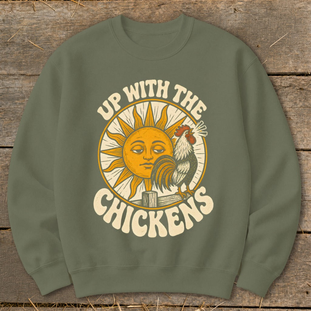Olive green crewneck sweatshirt featuring a graphic of a rooster, sun, and text reading Up With The Chickens.