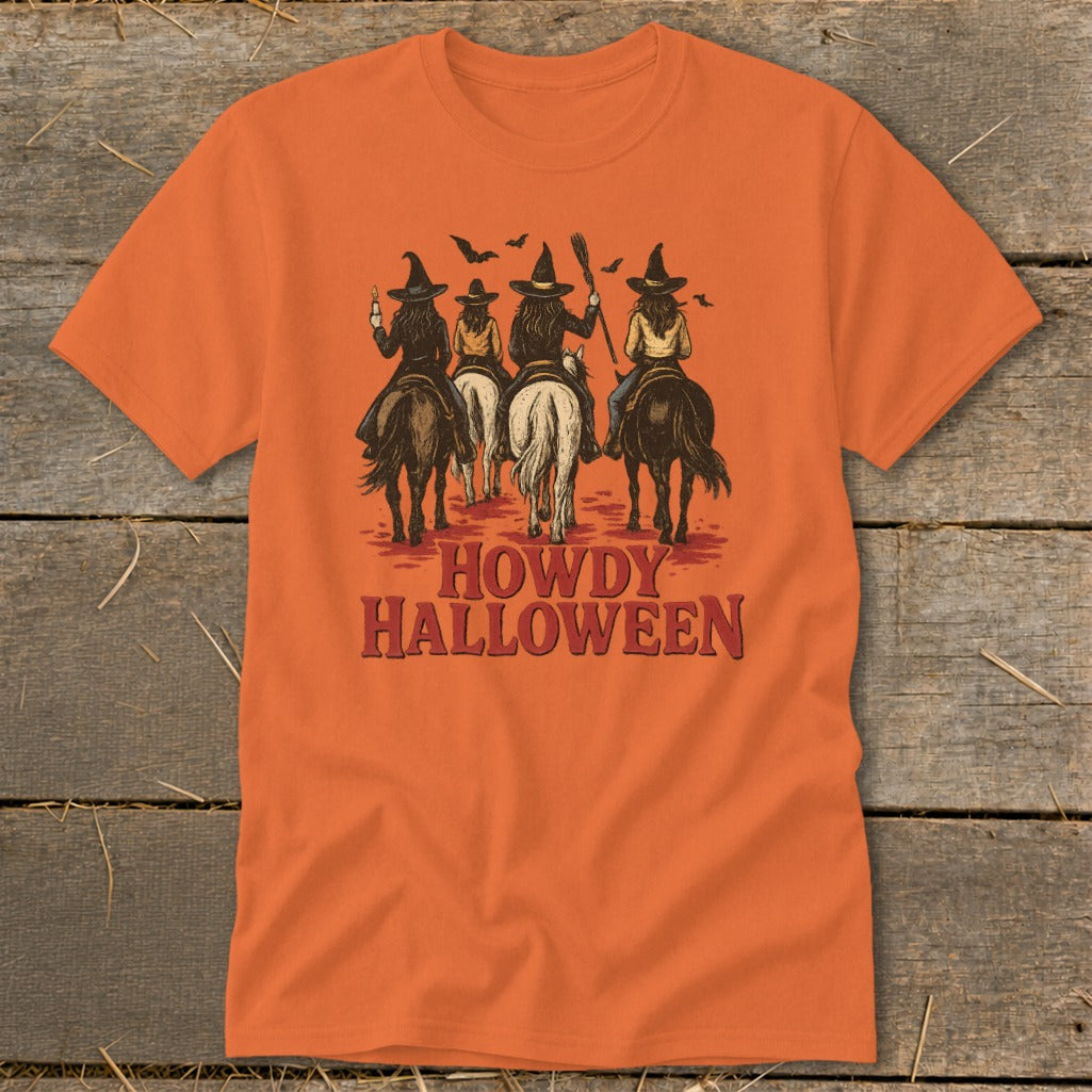 Orange t-shirt with four witches on horseback and text "Howdy Halloween".