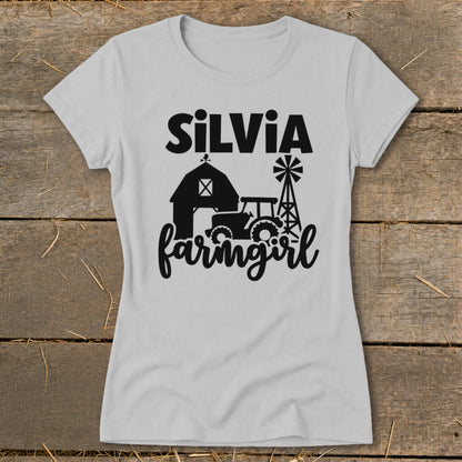 Light gray t-shirt with "SiLViA farmgirl" text and barn, tractor, and windmill graphic.