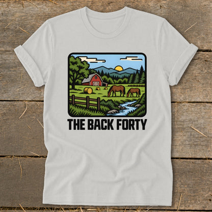 A light gray t-shirt featuring a farm scene with horses, a red barn, and the text The Back Forty.