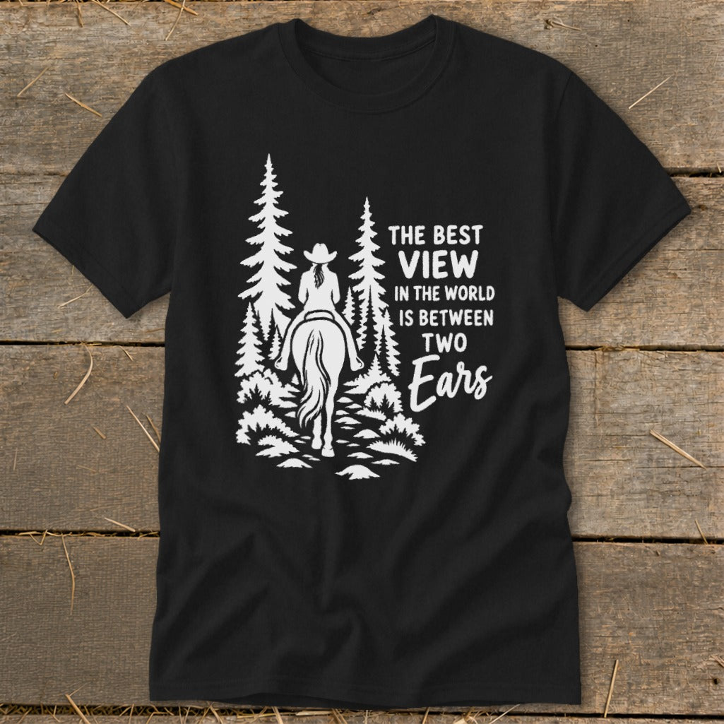 Black t-shirt featuring a white graphic of a horseback rider in the woods with the text The Best View In The World Is Between Two Ears.