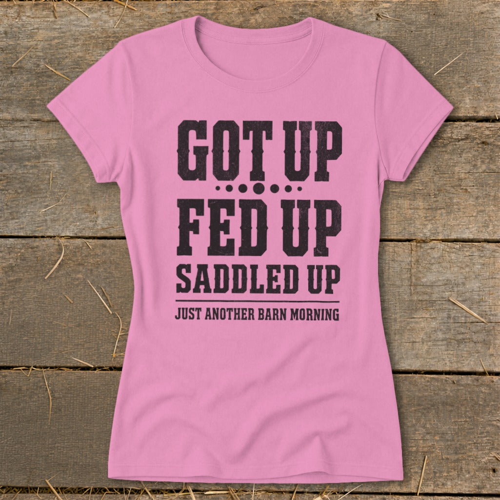 Pink t-shirt with black text reading "GOT UP FED UP SADDLED UP JUST ANOTHER BARN MORNING".