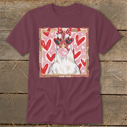 Chicken with heart sunglasses blowing bubblegum, on a pink heart background.