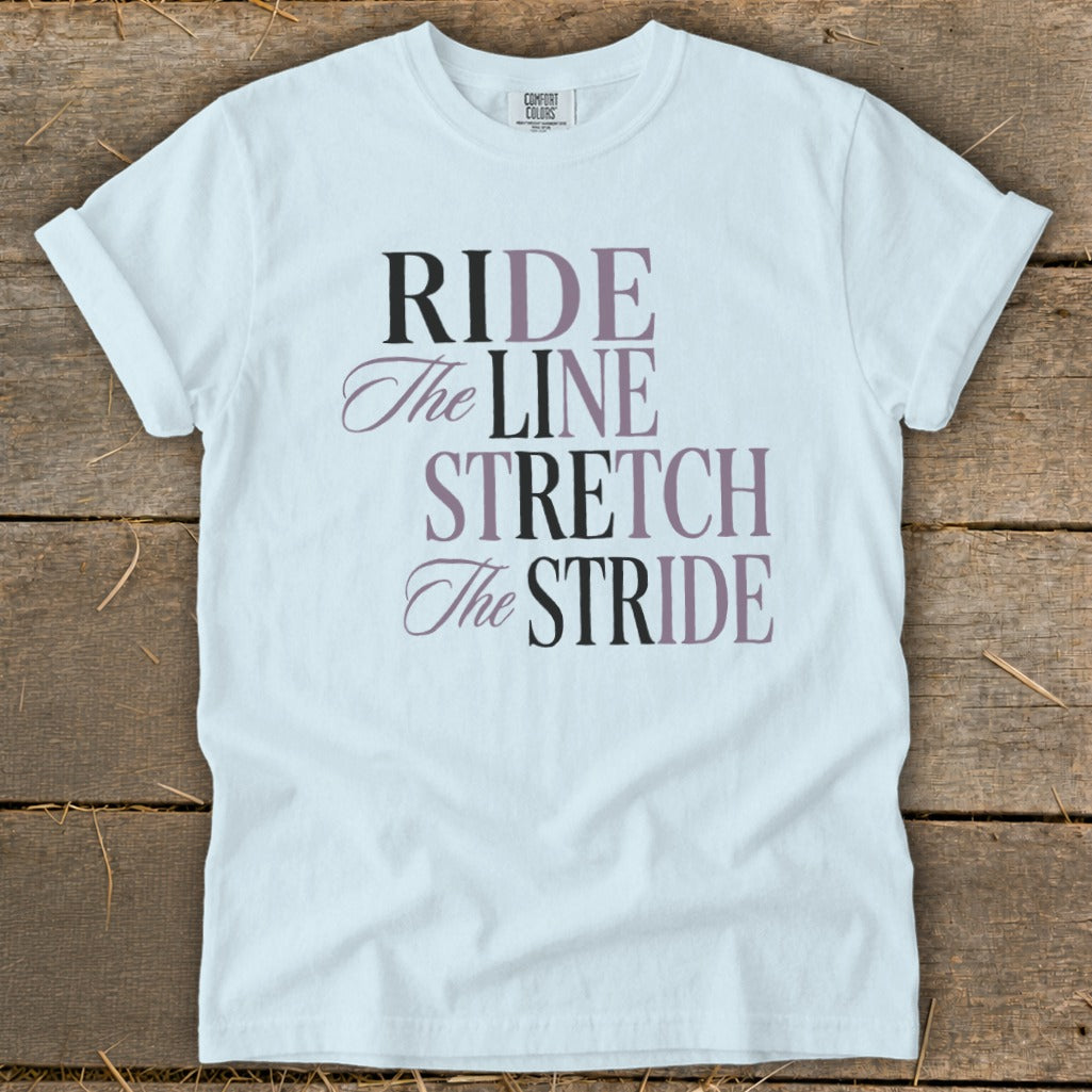 White t-shirt with text "RIDE The LINE STRETCH The STRIDE" in dark gray and plum.