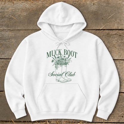 White hoodie with green text and graphic of boots filled with flowers.